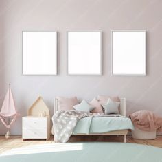 a bedroom with pink walls and two white framed pictures on the wall above the bed