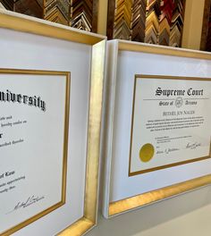 two framed diplomas sitting next to each other