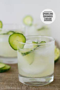 a glass filled with limeade and mints on top of a wooden table