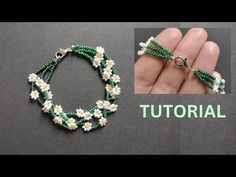 the beaded bracelet is being made with green and white beads, which are attached to a