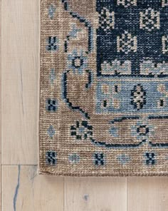 a blue and beige rug on top of a wooden floor