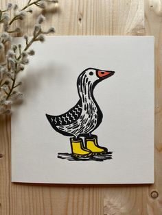 a drawing of a duck sitting on top of a yellow boot next to some flowers