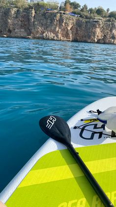 a kayak is sitting in the water near some cliffs