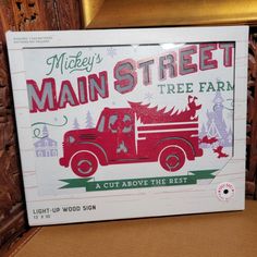 there is a sign that says mickey's main street tree farm in front of a chair