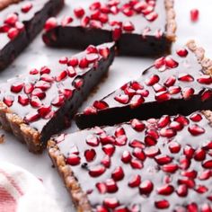 chocolate tart with pomegranates on top and one slice cut out