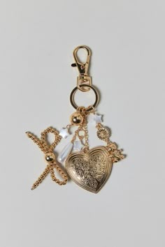 two charms are attached to each other on a key chain, one has a heart and the other is a cross