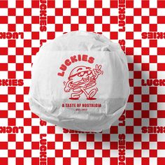 a sandwich wrapped in paper on top of a checkered tablecloth with the words lucky's