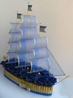 a blue and white model ship with gold trimmings on it's sails