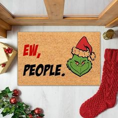 a door mat with the grin face on it and christmas decorations around it, along with other holiday items