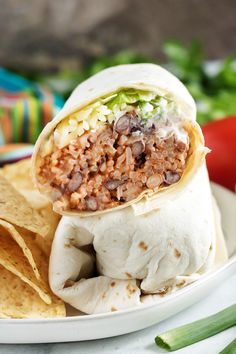 a burrito on a plate with tortilla chips