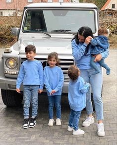 a group of children standing in front of a car