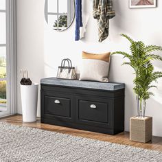 a black bench sitting next to a white wall and potted plant on top of it