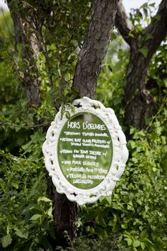 a plaque is hanging from a tree in the woods