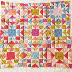 a crocheted blanket that has been made with different colors and patterns on it