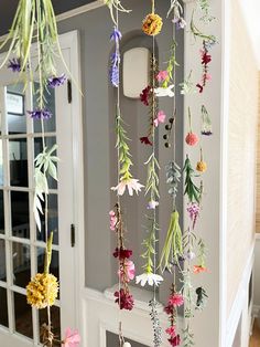 flowers are hanging from the ceiling in front of a white door with glass panels on it