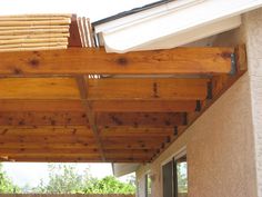 an outdoor covered patio area with sliding glass doors and wood slats on the roof