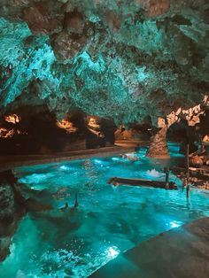 the inside of a cave filled with blue water