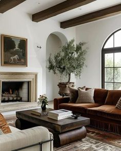 a living room filled with furniture and a fire place in front of a large window