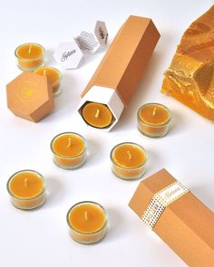 some candles are sitting next to boxes and paper tags on a table with other items