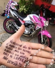 a person's hand with writing on it and a motorcycle in the back ground