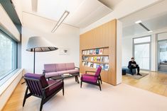 a living room filled with furniture next to a large window covered in lots of books