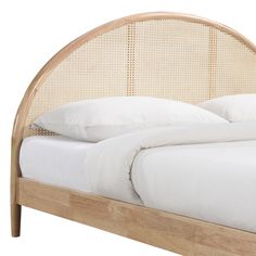 a bed with white sheets and pillows on top of it's headboard,