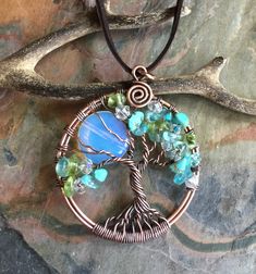 a tree of life pendant with blue and green beads