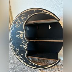 a black and gold moon shelf with two shelves