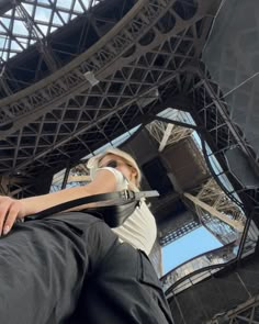 a woman standing in front of the eiffel tower with her hand on her hip