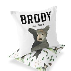 a pillow with a bear on it sitting next to another pillow