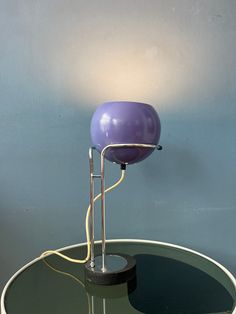 a purple lamp sitting on top of a glass table