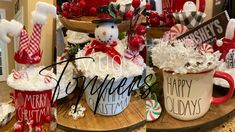 two mugs decorated with holiday decorations and candy canes are sitting on a table