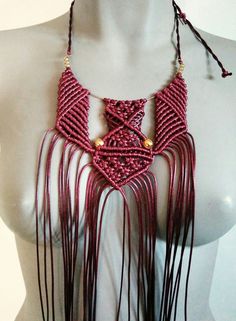 a mannequin wearing a red necklace with fringes and beads on it's neck