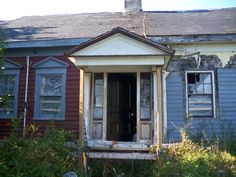 an old run down house with broken windows and boarded up shutters on the front door