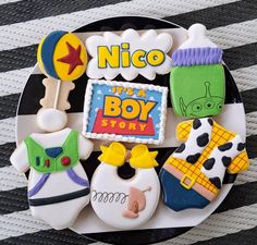 decorated cookies on a plate with the words nico and its boy story written in it