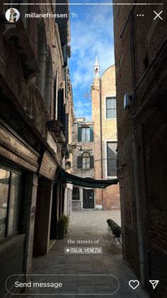 an alley way with buildings and a clock tower in the background