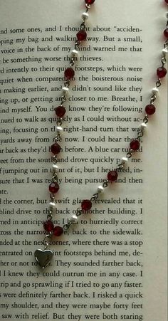 a book page with a red and white beaded necklace on it