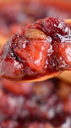 a spoon full of cranberry sauce on top of bread