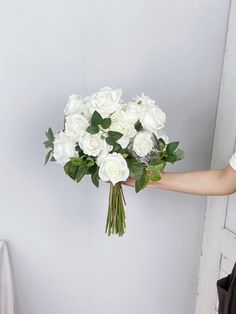 a person holding a bouquet of white flowers