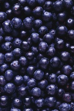 blueberries are piled high in the air