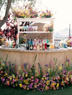 an outdoor bar with flowers and bottles on it