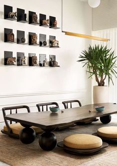 a dining room table with chairs and a plant in the center, on top of a rug