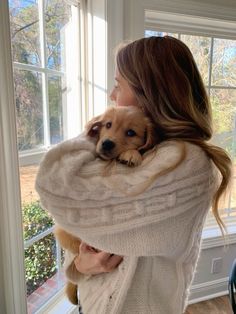 a woman holding a dog in her arms