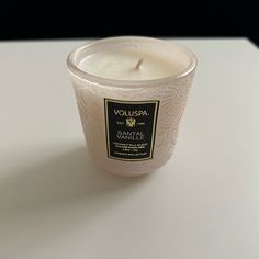 a white candle sitting on top of a table