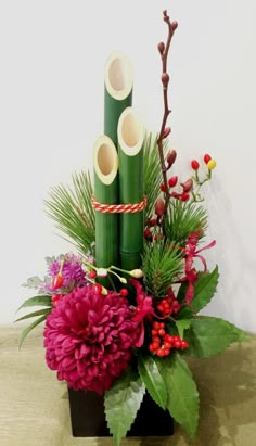 a vase filled with flowers and bamboo sticks