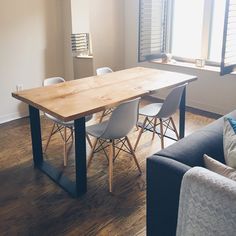 a wooden table sitting in the middle of a living room next to a blue couch