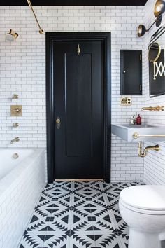 a black and white tiled bathroom with gold accents