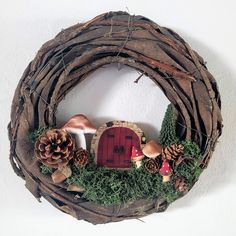 a wreath made out of branches with mushrooms and pine cones