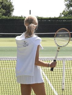 a woman holding a tennis racquet on top of a tennis court