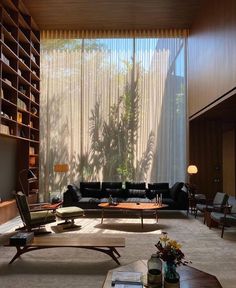 a living room filled with furniture and a large window covered in sheered drapes